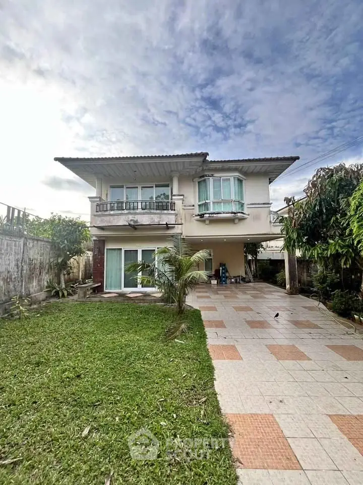 Charming two-story house with spacious garden and tiled driveway, perfect for family living.