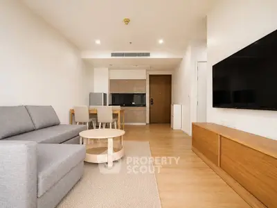 Modern living room with sleek furniture and open kitchen layout in a stylish apartment.