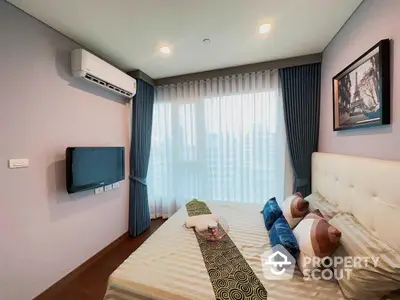 Cozy bedroom with a large bed, soft lighting, air conditioning, and a wall-mounted TV, perfect for relaxation and comfort.