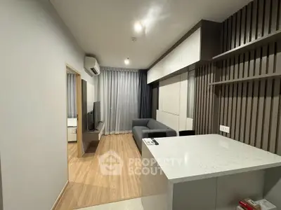 Modern living room with sleek design and open layout, featuring a cozy sofa and stylish cabinetry.