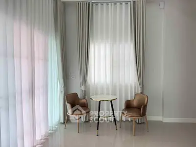 Elegant interior with modern chairs and table by large window, perfect for cozy conversations.