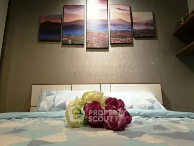 Cozy bedroom with modern art and floral decor, perfect for relaxation.