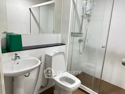 Modern bathroom with glass shower and sleek fixtures in a contemporary apartment.