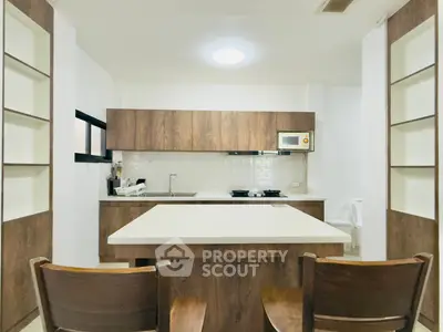 Modern kitchen with wooden cabinets and island in cozy apartment