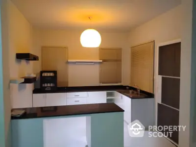 Charming kitchen space with modern appliances and ample counter space, featuring a sleek design and warm lighting.