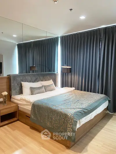 Luxurious bedroom with elegant decor and large windows in modern apartment.
