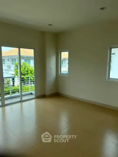 Spacious empty room with large windows and balcony access, offering a bright and airy atmosphere.