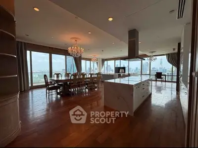 Luxurious open-plan living and dining area with panoramic city views and elegant chandeliers.