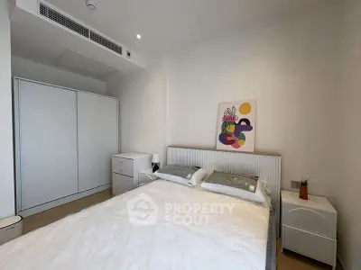 Modern bedroom with minimalist decor and stylish artwork, featuring a comfortable bed and ample storage space.