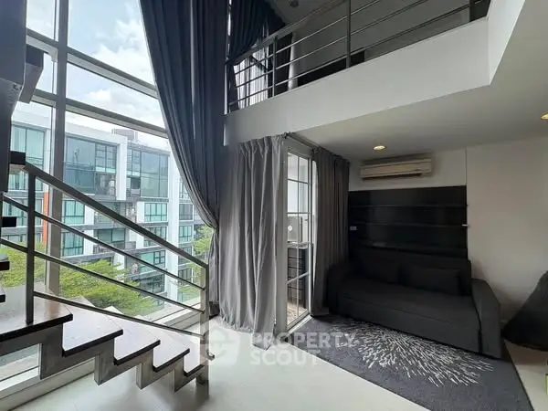 Modern duplex apartment with floor-to-ceiling windows and stylish staircase.