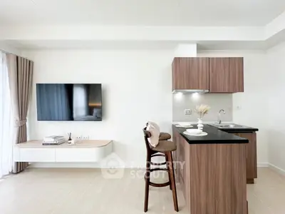 Modern open-layout kitchen with sleek cabinetry and breakfast bar in stylish apartment.