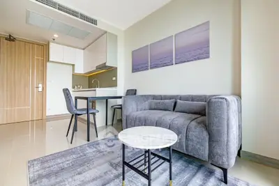 Modern living room with stylish gray sofa and open kitchen layout