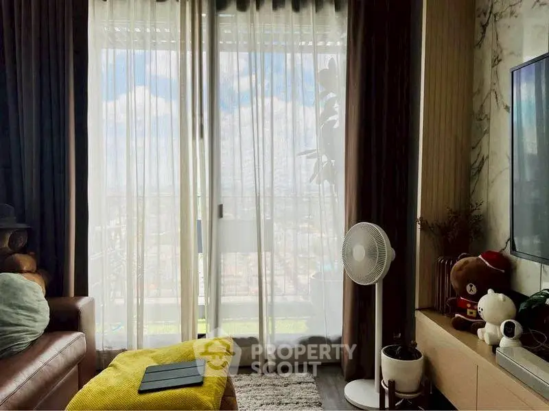 Cozy living room with balcony view, modern decor, and natural light.