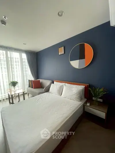 Modern bedroom with stylish decor and large windows offering natural light.
