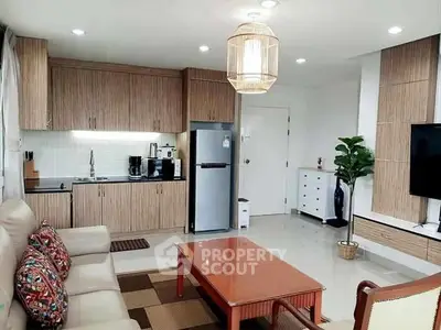 Modern living room with open kitchen, stylish decor, and cozy seating area.