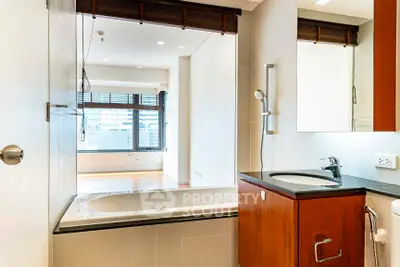 Modern bathroom with sleek design and city view from window, featuring a bathtub and stylish fixtures.