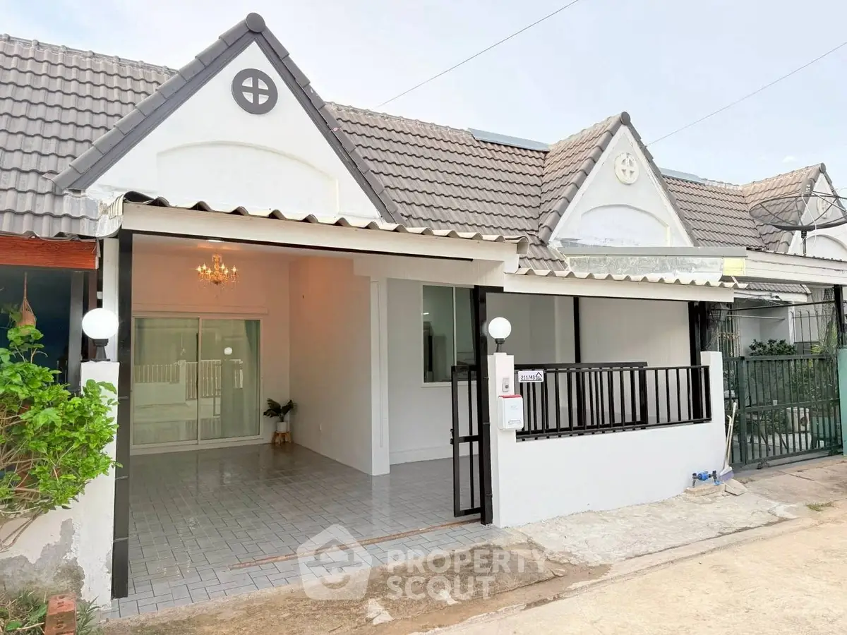 Charming single-story house with tiled roof and gated entrance, perfect for cozy living.