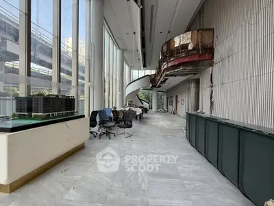 Spacious modern lobby with large windows and unique architectural design, ideal for commercial real estate.