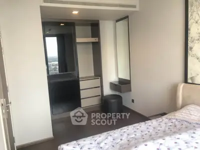 Modern bedroom with sleek built-in wardrobe and city view window, perfect for urban living.