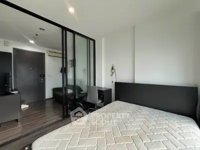 Modern bedroom with glass partition and study area in a stylish apartment