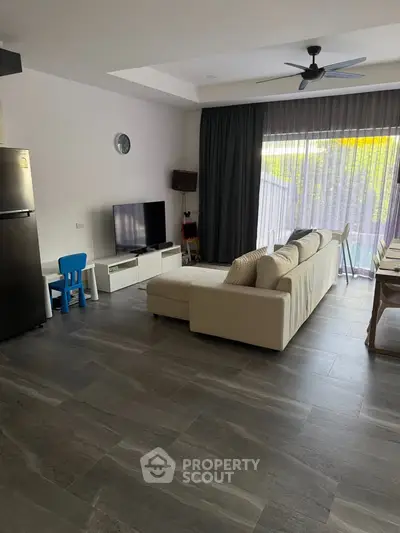 Spacious modern living room with large windows and stylish furniture, perfect for family gatherings.