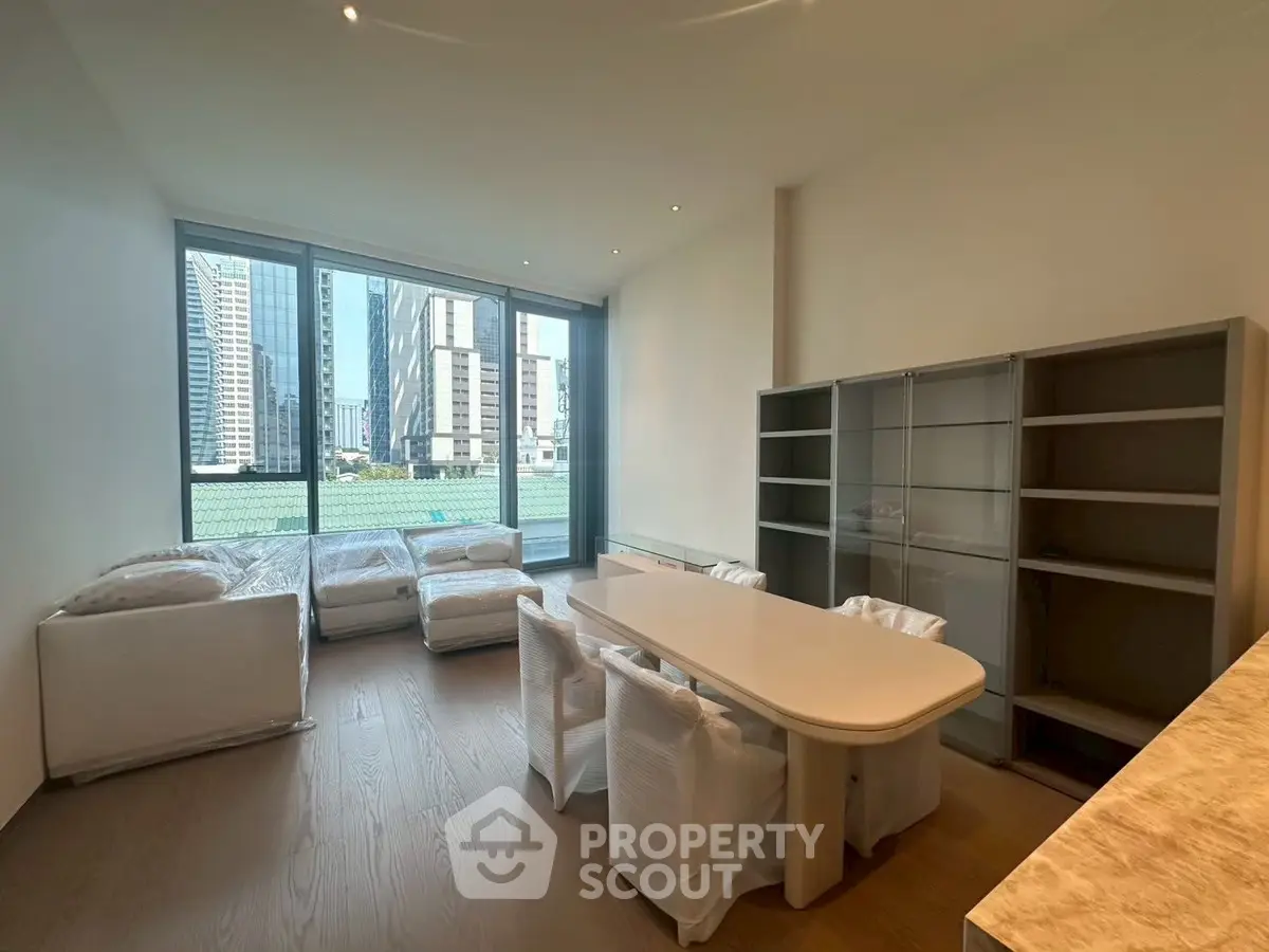 Spacious modern living room with large windows and city view, featuring elegant dining area and ample natural light.