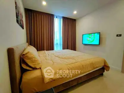 Cozy bedroom with modern decor and wall-mounted TV, featuring warm lighting and elegant curtains.