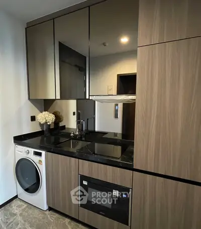 Modern kitchen with sleek cabinetry, built-in appliances, and elegant black countertops.
