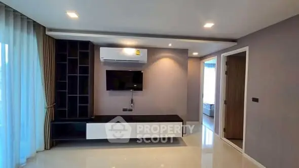 Modern living room with sleek TV unit and air conditioning in a stylish apartment.