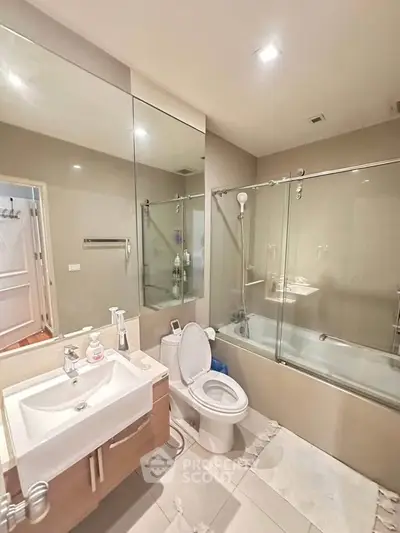 Modern bathroom with glass shower and sleek fixtures in a contemporary home.