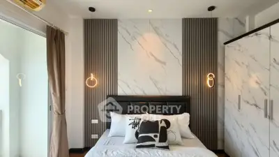 Modern bedroom with stylish decor and marble accents, featuring a cozy bed and elegant lighting.