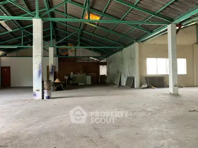 Spacious industrial warehouse with high ceilings and ample natural light.