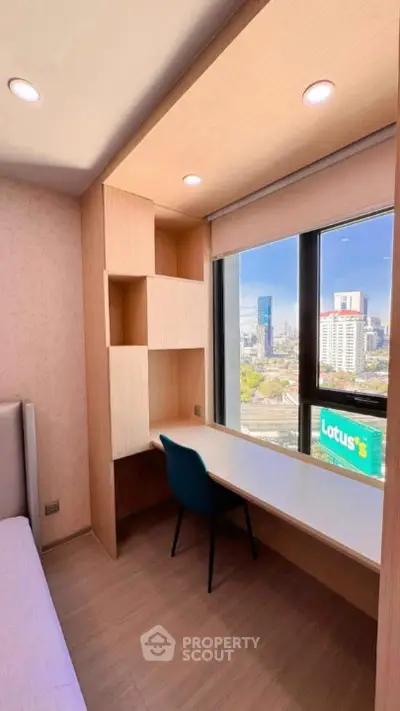 Modern study room with city view, built-in desk, and shelving in a high-rise apartment.