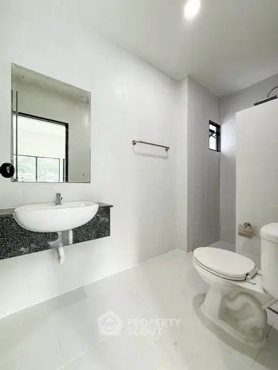 Modern white bathroom with sleek fixtures and natural light