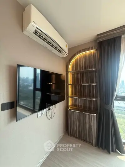 Modern living room with wall-mounted TV and stylish shelving unit, featuring a large window with city view.
