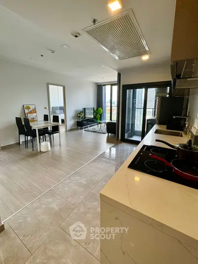 Modern open-plan kitchen and living area with sleek design and ample natural light.