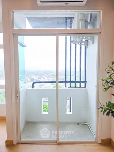 Modern apartment balcony with sliding glass doors and city view