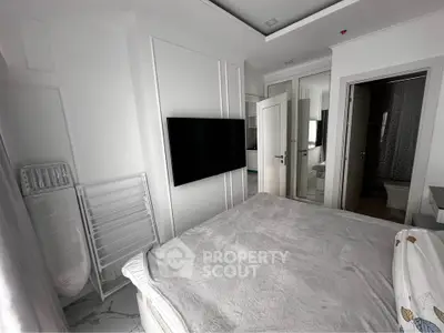 Modern bedroom with sleek design and wall-mounted TV