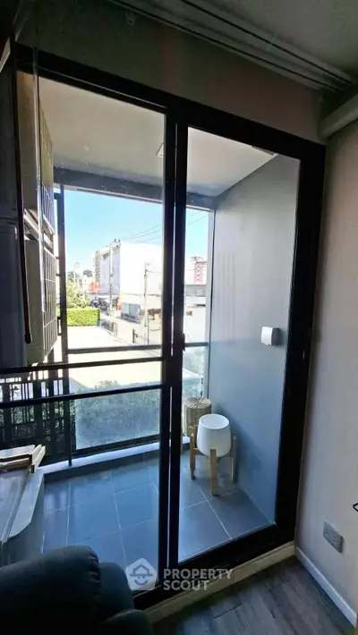 Modern apartment balcony with glass doors and city view