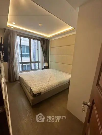 Modern bedroom with large window and stylish lighting in a contemporary apartment.