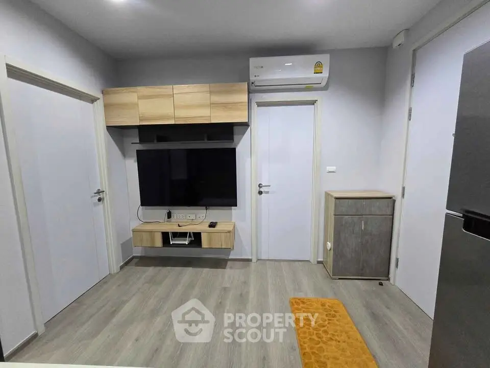 Modern living room with sleek TV setup and air conditioning in a stylish apartment.