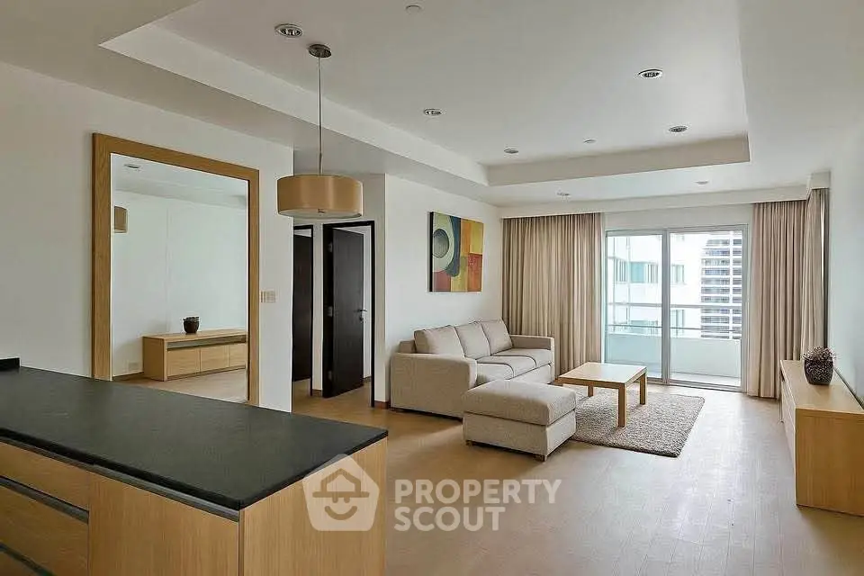 Spacious modern living room with elegant decor and large windows offering natural light.