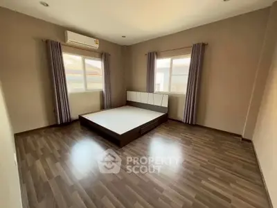 Spacious bedroom with modern flooring and ample natural light