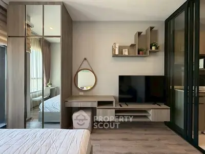 Modern bedroom with stylish decor, large mirror, and sleek TV setup.