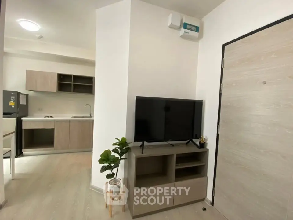 Modern apartment interior with open kitchen and stylish living area, featuring sleek furniture and natural light.