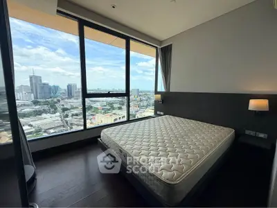 Modern bedroom with stunning city view and large windows in high-rise apartment.