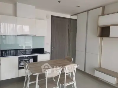Modern kitchen with sleek cabinetry and dining area in contemporary apartment