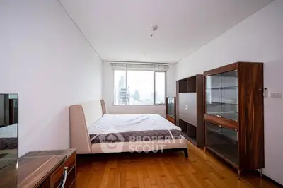 Spacious modern bedroom with city view and elegant wooden furniture.