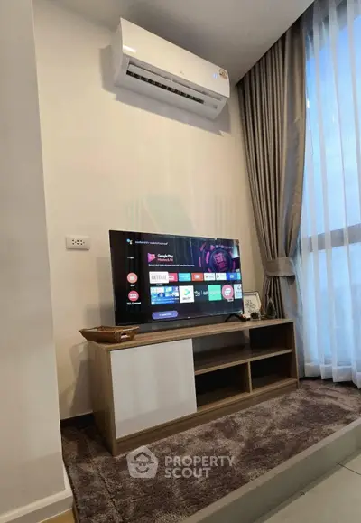Modern living room with sleek TV setup and air conditioning, featuring floor-to-ceiling windows and elegant curtains.