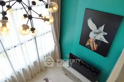 Stylish modern living room with teal walls, unique chandelier, and elegant artwork.